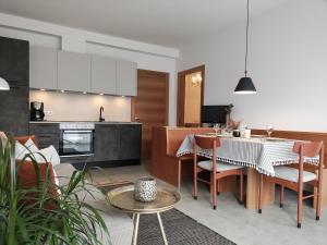 eine Küche und ein Wohnzimmer mit einem Tisch und Stühlen in der Unterkunft Apartment Matthäus in Tscherms