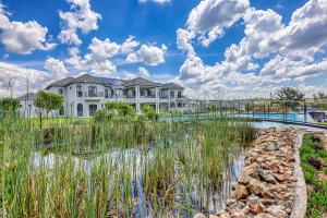 una casa grande con un estanque frente a ella en Villa Tasha Luxury Suites, Lanseria, en Johannesburgo