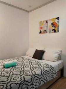 邦勞的住宿－Mannah Garden Staycation Place，一间卧室配有一张带黑白色棉被的床