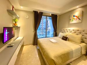 - une chambre avec un grand lit et une télévision dans l'établissement Comfort and Luxury Private Room at Goldcoast PIK, à Jakarta