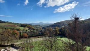 a view of a valley with trees and mountains at Gîte Le Grenier de l'Oasis de Chamousset in Brullioles