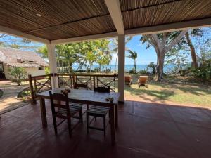 a table and chairs on a porch with a view of the ocean at Villa Colibri in Nosy Be