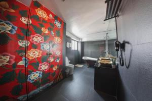 un bagno con una parete rossa e fiori di Dalai-La Boutique Hotel a Kathmandu
