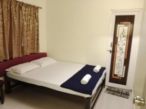 a bedroom with a bed and a window with a mouse on it at HOTEL SUNANDA LODGE in Belgaum