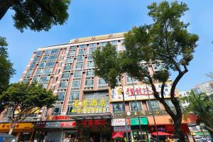 een groot gebouw aan een stadsstraat met bomen bij Mei Gang Hotel in Guangzhou