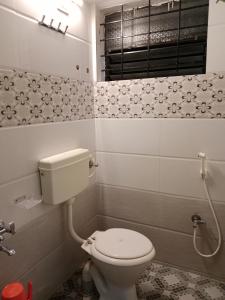 niewielka łazienka z toaletą i oknem w obiekcie HOTEL SUNANDA LODGE w mieście Belagavi