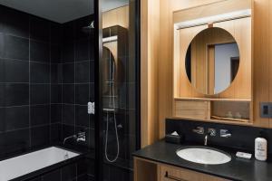 a bathroom with a sink and a shower and a mirror at Ace Hotel Kyoto in Kyoto