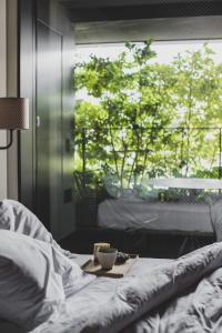 a tray with a cup on a bed with a window at Ace Hotel Kyoto in Kyoto