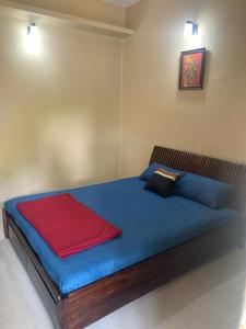 a bedroom with a blue bed with a red blanket at RD's abode in Kozhikode