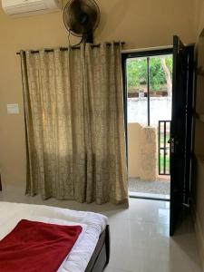 a bedroom with a bed and a door with a window at RD's abode in Kozhikode