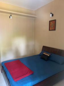 a bedroom with a blue bed with a red blanket at RD's abode in Kozhikode