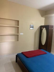 a bedroom with a bed and a mirror and shelves at RD's abode in Kozhikode
