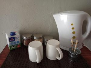 un mostrador con dos tazas de café blancas y una licuadora en Campbell Stays en Kestell