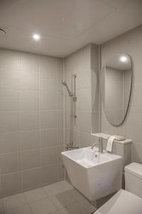 bagno con lavandino, servizi igienici e specchio di Stay Dooroo a Suncheon