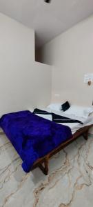 a bed with a blue blanket on it in a room at Supritha Homestay Hampi in Hampi