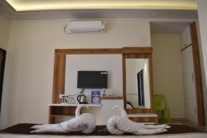 2 cygnes assis sur un lit dans une pièce dans l'établissement SEA LUXE Beach Resort, à Dapoli