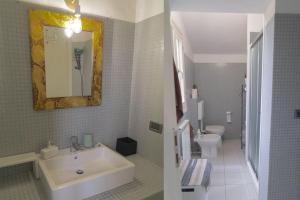 a white bathroom with a sink and a toilet at La Casa di Alice, comfort tra Modena e Maranello in Montale