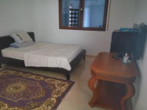 una piccola camera con letto e tavolo di Villa Alhucemas 
