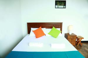 a bedroom with a bed with colorful pillows on it at Eden Rock Luxurious Accommodation in Kandy