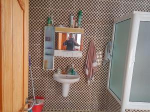 osoba robiąca zdjęcie łazienki z umywalką w obiekcie Villa Alhucemas 