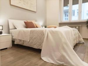 QuickHome Appartamento Edera في بييلا: غرفة نوم مع سرير مع لحاف أبيض