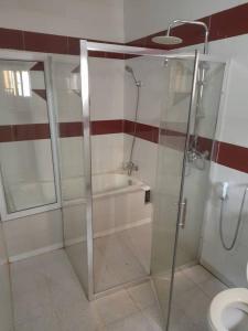 łazienka z prysznicem, wanną i toaletą w obiekcie Bijilo Villa w mieście Bijilo