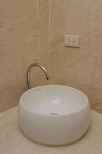 un lavandino bianco con rubinetto in bagno di Care Villa Koh Phangan a Ko Phangan
