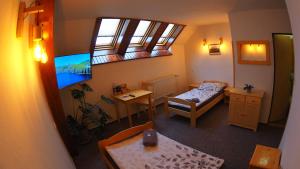 Habitación pequeña con 2 camas y mesa. en HOTEL BRITANNIA VSETÍN en Vsetín