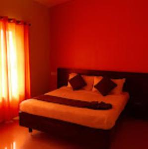 Un dormitorio con una cama con paredes rojas y una ventana en Park Place Holiday Home Kerala, en Vythiri