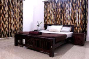 1 dormitorio con 1 cama y 1 mesa en una habitación en Helen's Villa Kerala, en Kalpetta