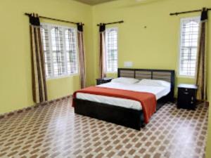 a bedroom with a large bed and two windows at Himadri Retreat Homestay Wayanad in Kaniyāmbetta