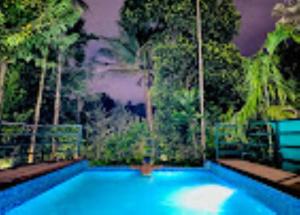 una gran piscina azul con árboles en el fondo en Park Place Holiday Home Kerala, en Vythiri