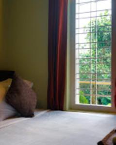 1 dormitorio con cama y ventana grande en Park Place Holiday Home Kerala, en Vythiri