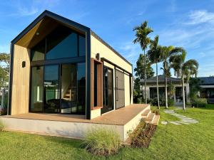 a house with large glass windows on a lawn at Annie Villa at Khao Yai in Mu Si