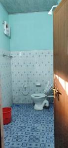 a bathroom with a white toilet in a room at Himadri Retreat Homestay Wayanad in Kaniyāmbetta