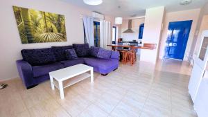 sala de estar con sofá púrpura y mesa en Villa Playa Blanca, en Playa Blanca