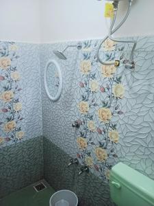 a bathroom with a shower with flowers on the wall at Rose Villa Pondicherry in Puducherry