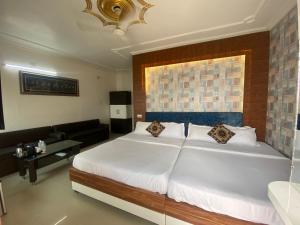 a bedroom with a large white bed and a couch at Hotel Sita Palace On Heritage Ghats Of Benaras in Varanasi