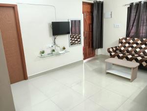 a living room with a couch and a tv at Rose Villa Pondicherry in Puducherry
