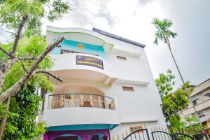 Un edificio blanco con balcón y palmeras. en SPOT ON Nirvaan Guest House, en Kāhārpāra 24 fotos más
