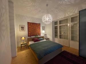 Schlafzimmer mit einem Bett und einem Kronleuchter in der Unterkunft Apartment ANKA in Bad Ischl