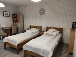 a room with two beds and a desk with a table at Pokoje-Gorlice-Zawodzie in Gorlice