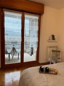 a bedroom with a bed and a glass door with a window at Appartamento raffinato su Roma zona Aurelia in Rome
