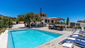 una piscina con sillas y una casa en Rincón de Elena, en Quéntar