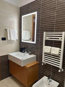ein Badezimmer mit einem Waschbecken, einem Spiegel und einem WC in der Unterkunft Appartamento raffinato su Roma zona Aurelia in Rom