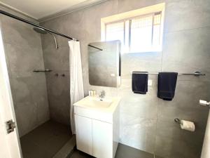 uma casa de banho branca com um lavatório e um chuveiro em Adrian Motel em Forbes