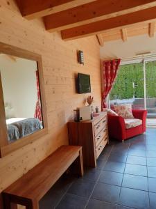 a living room with a red couch and a mirror at Au Cœur des Lacs - Chambres d'hôtes in Gérardmer