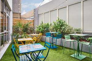 an outdoor patio with tables and chairs and plants at Campanile Paris Sud - Porte d'Orléans - Arcueil in Arcueil