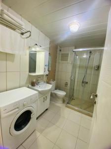 a bathroom with a sink and a washing machine at Liman Apart Hotel in Isparta