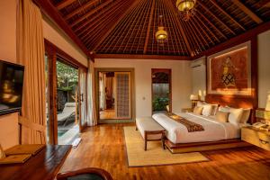 a bedroom with a large bed and a balcony at Nau Villa Ubud in Tegalalang